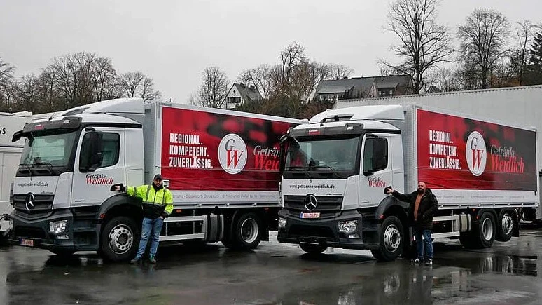 Zwei Weidlich-LKWs mit ihren Fahrern vor dem Start | Getränke Weidlich 